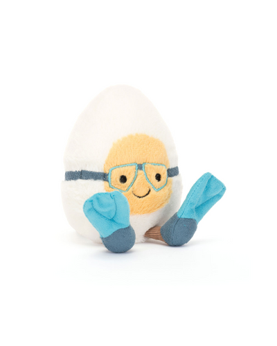 The Jellycat Amuseables Boiled Egg Scuba Outfit is a plush toy shaped like a white egg with a yellow face, blue glasses, a smiling mouth, and blue flipper feet. It sits on a white background and is made from soft polyester fibers.