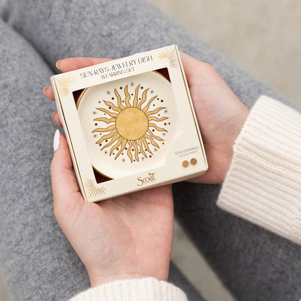 A person in a cream sweater holds a boxed ceramic jewelry dish and stud earring set titled 