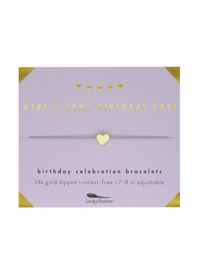 The Birthday Celebration Bracelet card includes a 14k gold-dipped heart charm on a gray string. The card says "Here's Some Birthday Love." The bracelet is nickel-free, adjustable, and measures 7-8 inches.