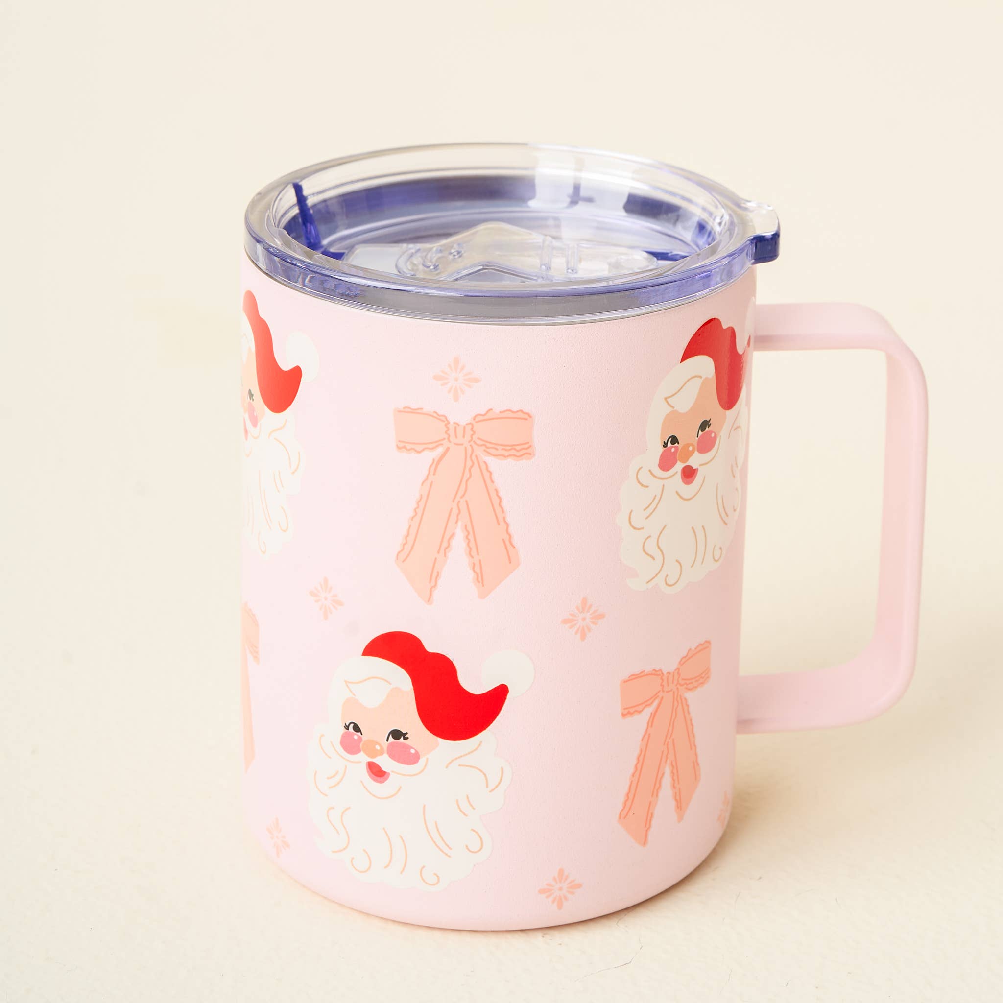 Close-up of a coquette-inspired pink Santa mug with pink bows and whimsical Santa faces. Ideal for a festive, girly aesthetic.