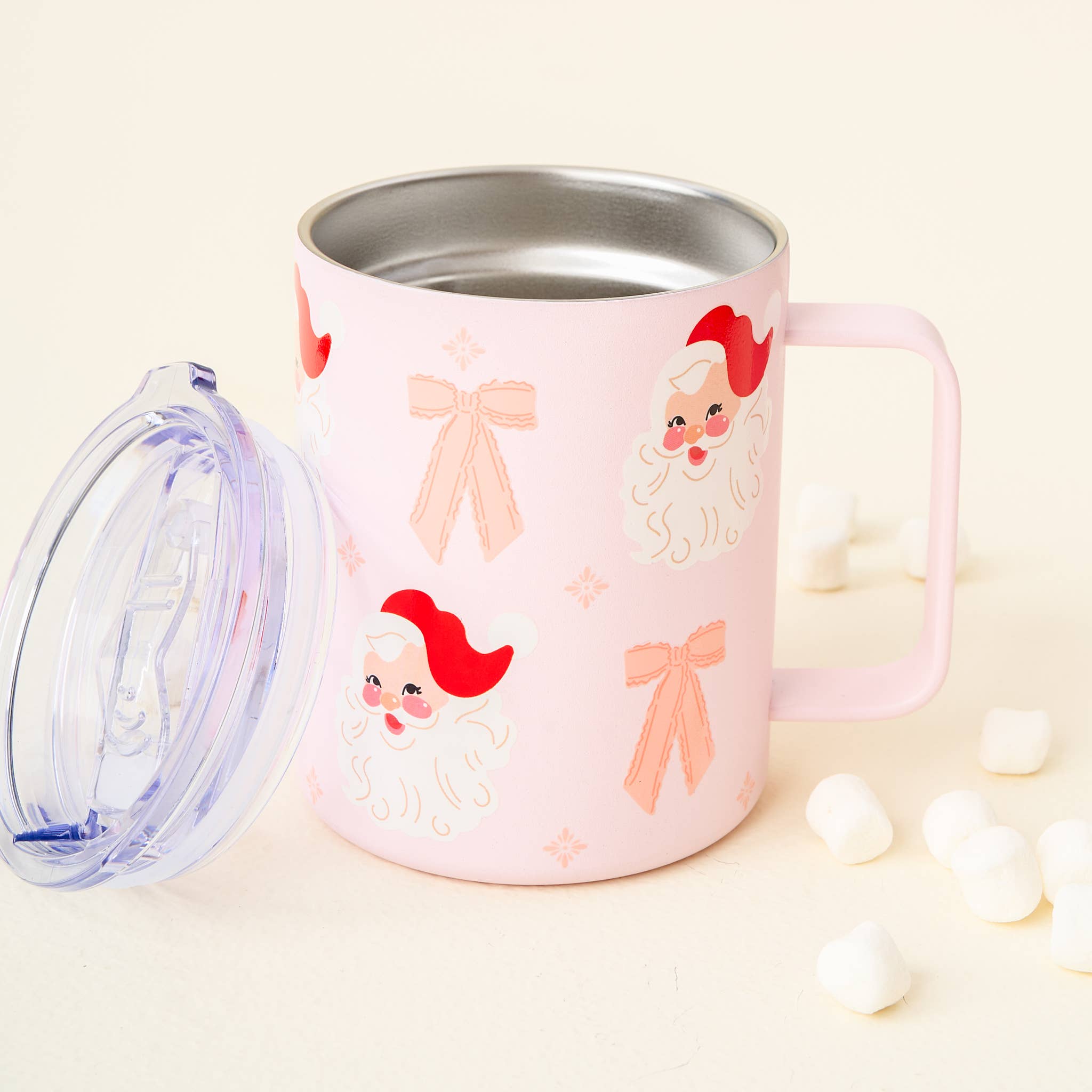 Pink coquette style mug with Santa faces and pink bow designs, with a clear lid removed. Perfect holiday mug for adding a feminine, vintage touch.