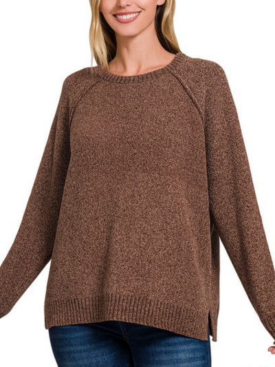 A person dressed in the Susan Chenille Sweater in a rich brown hue, featuring a relaxed fit and ribbed cuffs and hem, smiles softly while effortlessly pairing it with blue jeans.