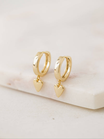 Everly Heart Huggie Drop Hoop Earrings in gold featuring a 12mm hoop and a 7mm dangling heart charm.