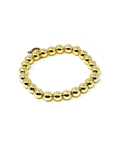 The Powerbeads by Jen Gold Hematite Stackable Bracelet is a stretchable gold bracelet with polished, evenly sized round beads linked together. It features gold hematite PowerBeads, known for their grounding properties, and is arranged circularly on a white background.