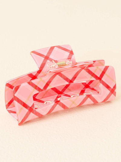 Close-up view of a rectangular acrylic hair claw in a pink plaid pattern with red crisscross lines, showcasing its sturdy clasp and open design.