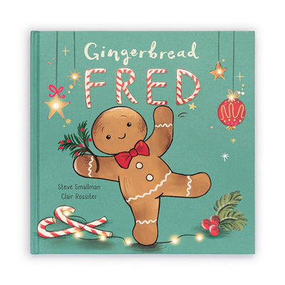 The cover of the "Jellycat Gingerbread Fred Book" features a joyful gingerbread man adorned with a red bowtie, surrounded by candy canes, stars, and holly. The holiday spirit is further enhanced by a festive green background. Authors: Steve Smallman and Clair Rossiter.