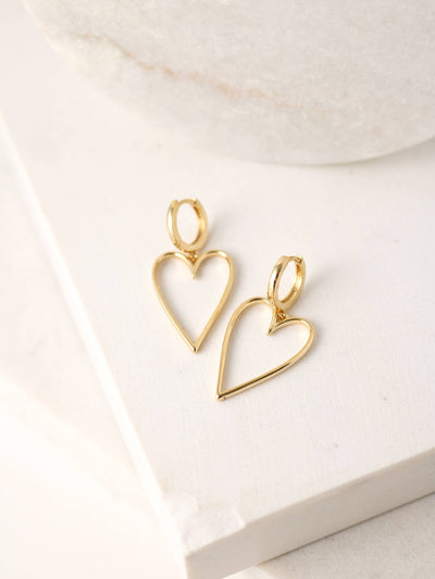 Lovestruck Heart Hoop Earrings in gold featuring a 12mm hoop and dangling open heart charm.