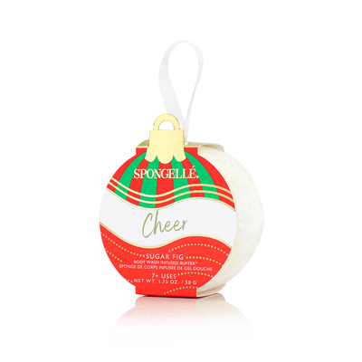 Introducing the Spongelle Holiday Ornament - Cheer, featuring a holiday-themed packaging that houses a skin care ornament with a sponge infused with sugar fig body wash. This delightful product resembles a red and green plaid ornament complete with a gold cap and white hanging loop. Embellished with the brand name "Spongellé," along with "Cheer" and "body wash infused buffers," it makes for an ideal holiday gift.