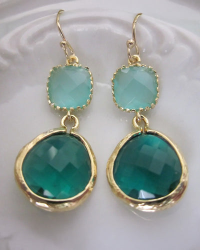 Emerald Green Earrings Aqua Mint: Gold-plated dangle earrings with square light green gems above larger round faceted teal stones, elegantly displayed on a white textured surface—ideal for gifting.