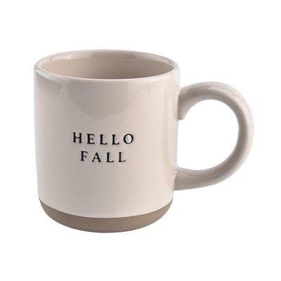 This Stoneware Mug - Hello Fall showcases a rustic style with a beige ceramic design adorned with "HELLO FALL" in black print. It features a darker brown band at the base and a large handle, ideal for complementing farmhouse decor.